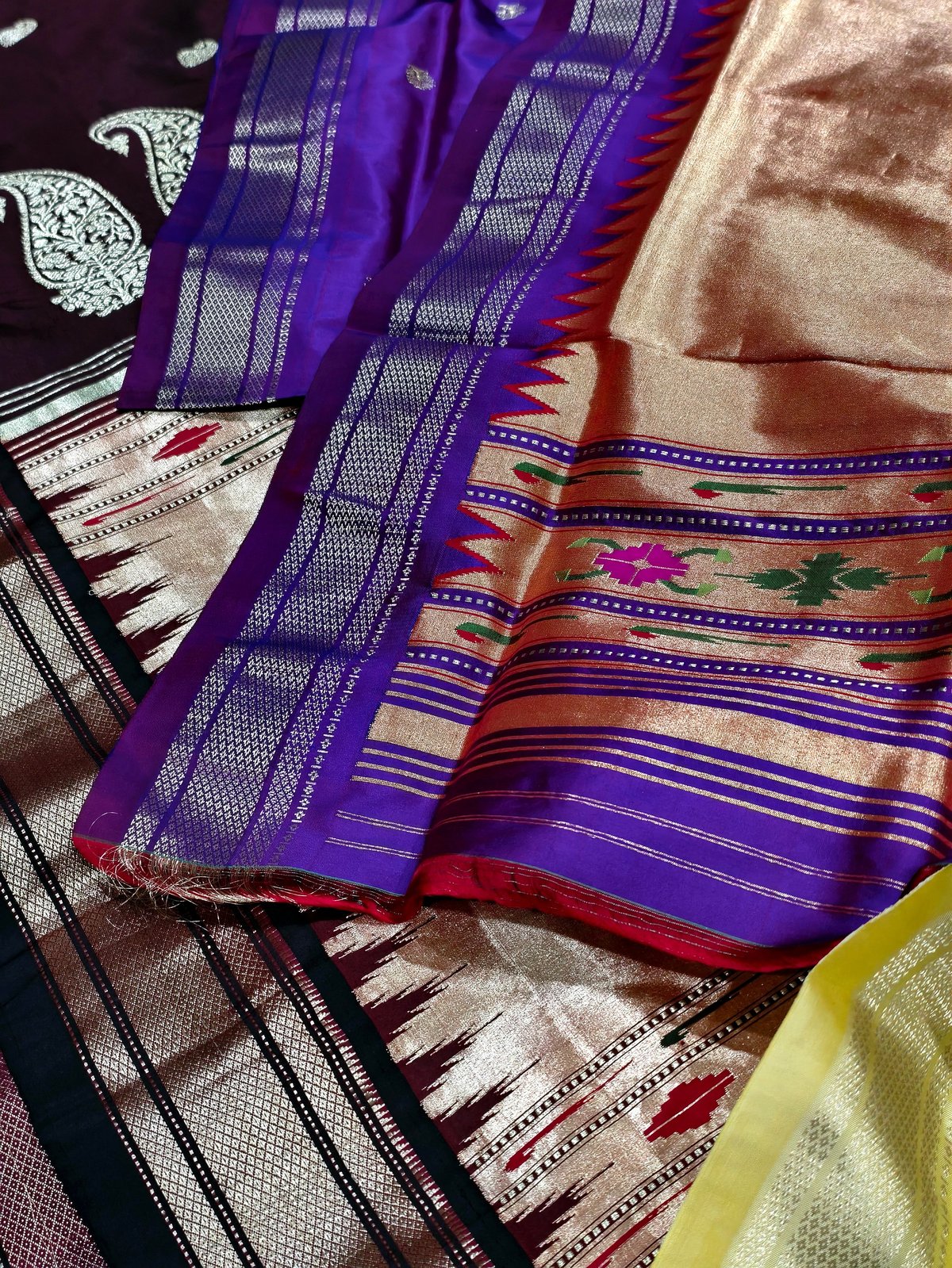 Folded stacks of traditional South Asian handwoven silk sarees in jewel tones